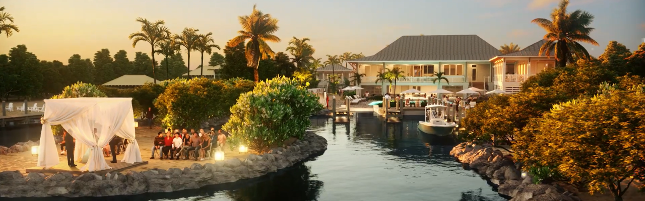 A waterfront wedding ceremony at sunset with a decorated arch, guests seated, surrounded by palm trees and a house in the background.